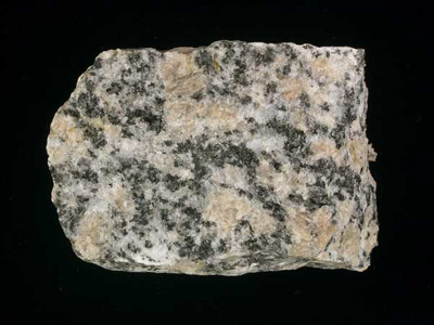 Hand speciment of granite; pink and white are feldspars; blackish specks are biotite mica.