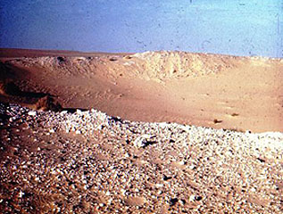 Ground view of the Wabar crater, with sandstone-like ejecta, often coated with black glass.